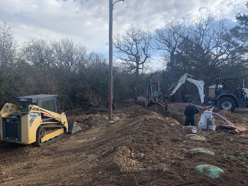 Skid steer and excavator on a septic installation site