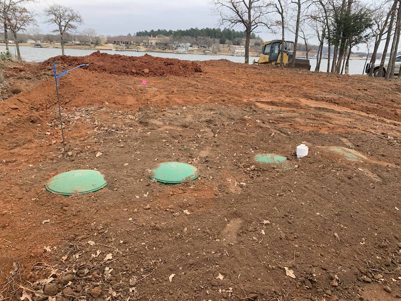 Septic access lids on a sloped lakeside lot