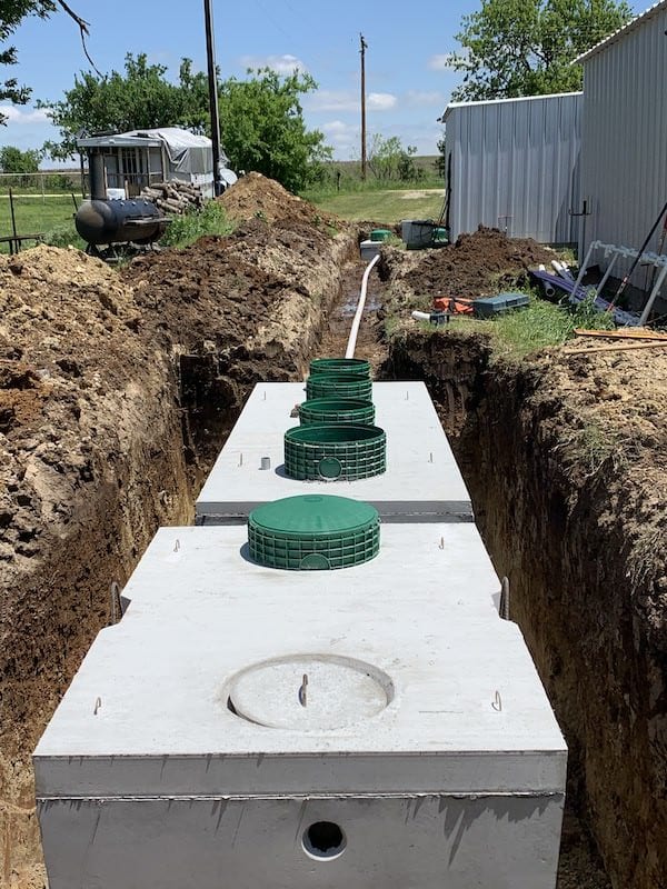 Concrete septic tanks set in an excavated trench